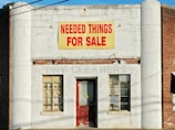 needed things for sale poster posted on white concrete establishment