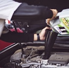 man refilling motor oil on car engine bay