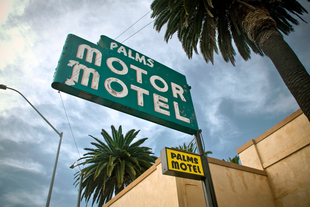 green and white palms motor motel signage outdoor during daytime