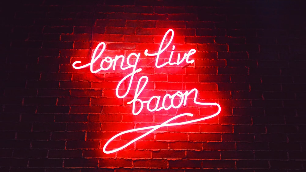 Red Ling Live Bacon Neon Light Signage su mattoni marroni del muro