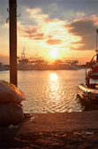 Sunset over the Mediterranean coast with fishing boats gently bobbing in the harbor.