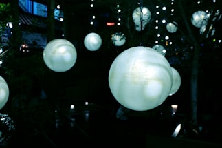 A serene scene of a woman meditating outdoors surrounded by soft glowing light orbs.