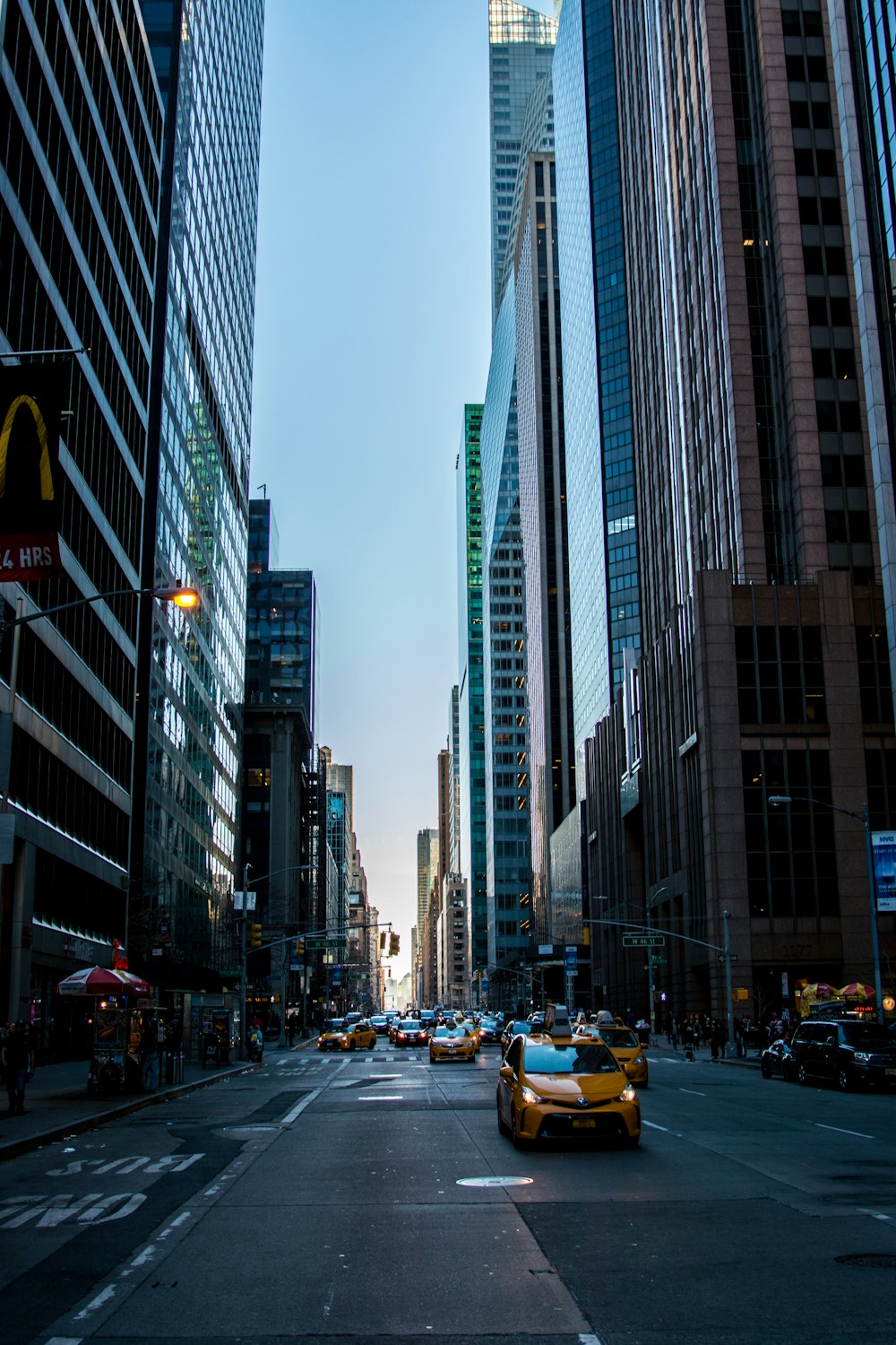 yellow vehicle on road between buildings