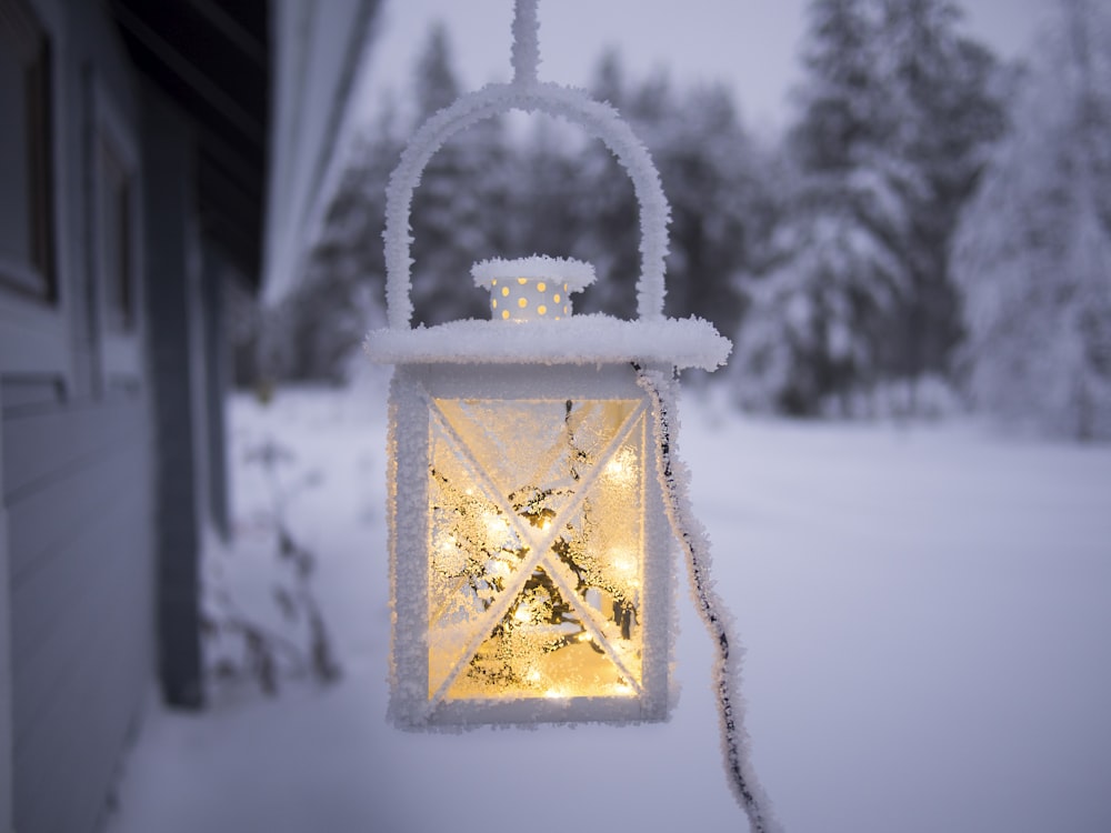 Lámpara colgante blanca que cuelga en el techo fuera del bosque cubierto de nieve