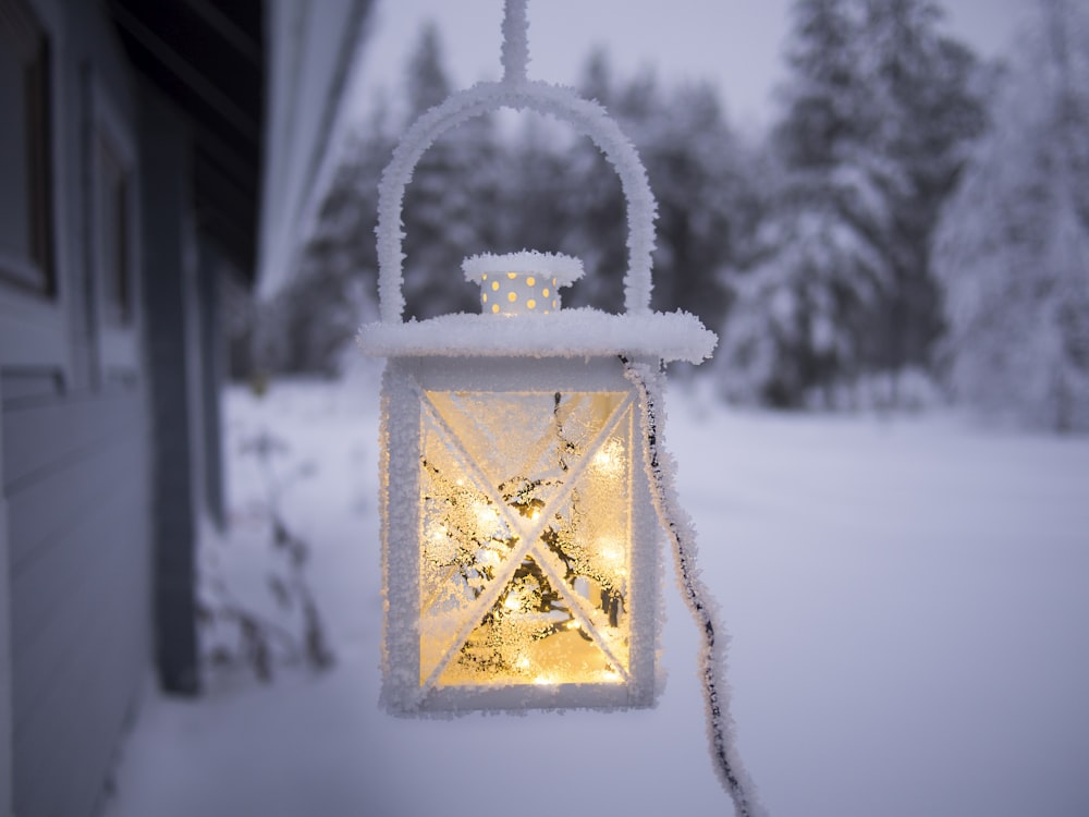 weiße Pendelleuchte, die außerhalb eines schneebedeckten Waldes an der Decke hängt