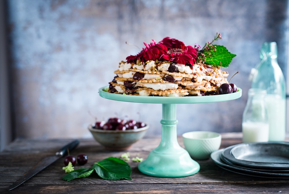 Kuchen auf Tortenständer neben Milch auf Milchflaschen