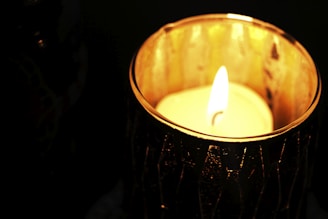 Close-up of a glowing candle nestled in a smooth, handmade cement holder.