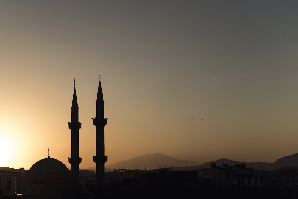 two mosque minarets under calm sky