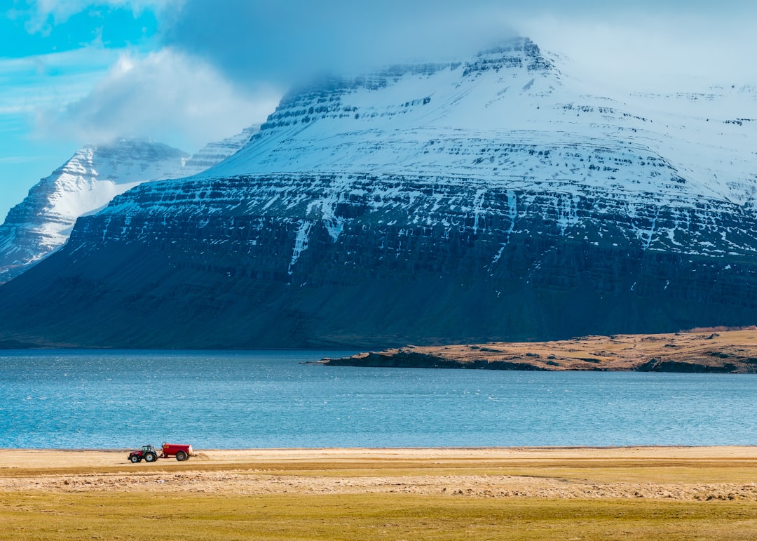 snow capped mountain next to body of water