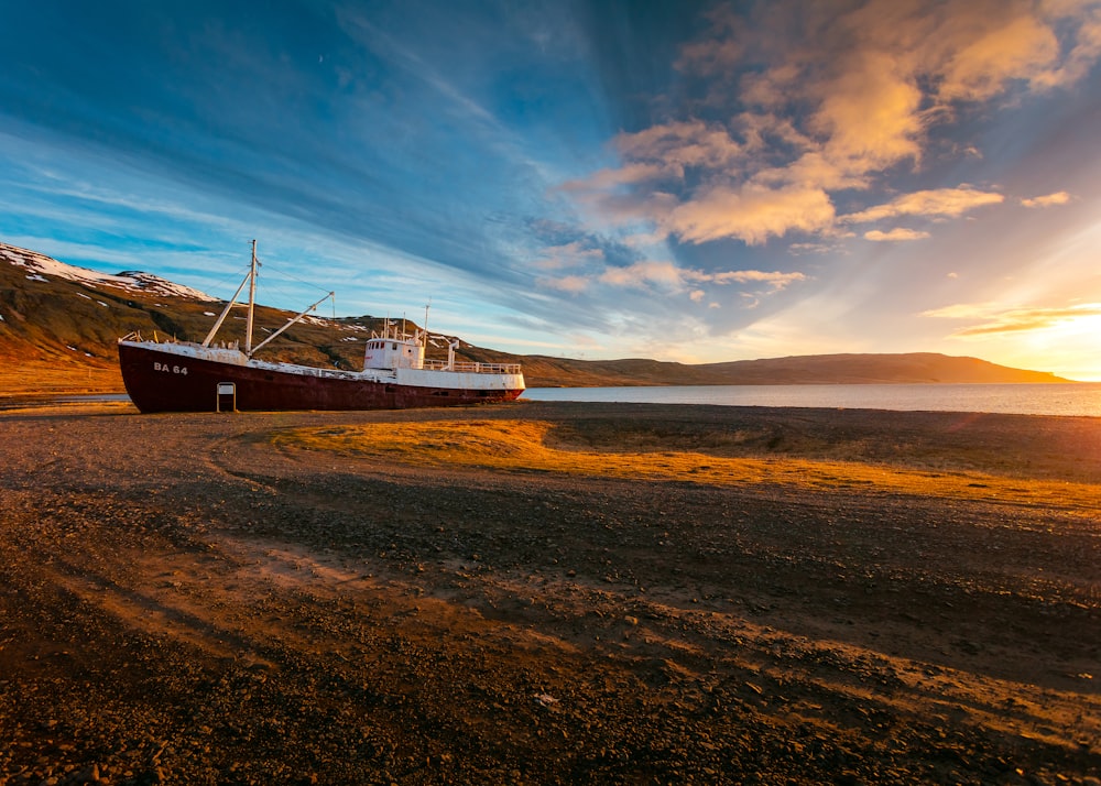 brown and white boat docked under blue and white sky