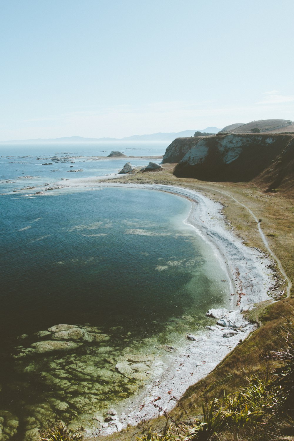 ocean waves beside brown mountain