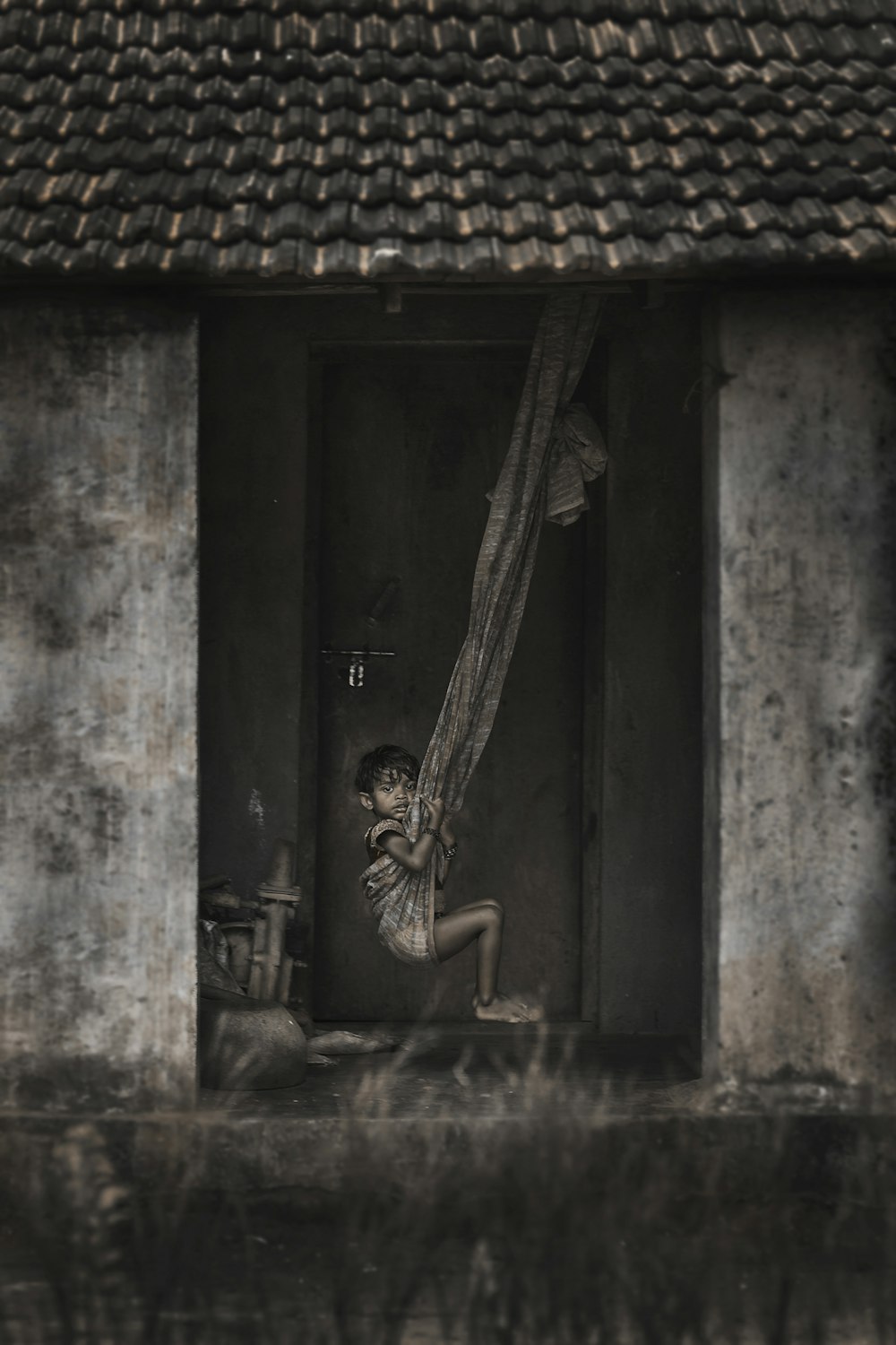 Foto en escala de grises de una chica montando hamaca