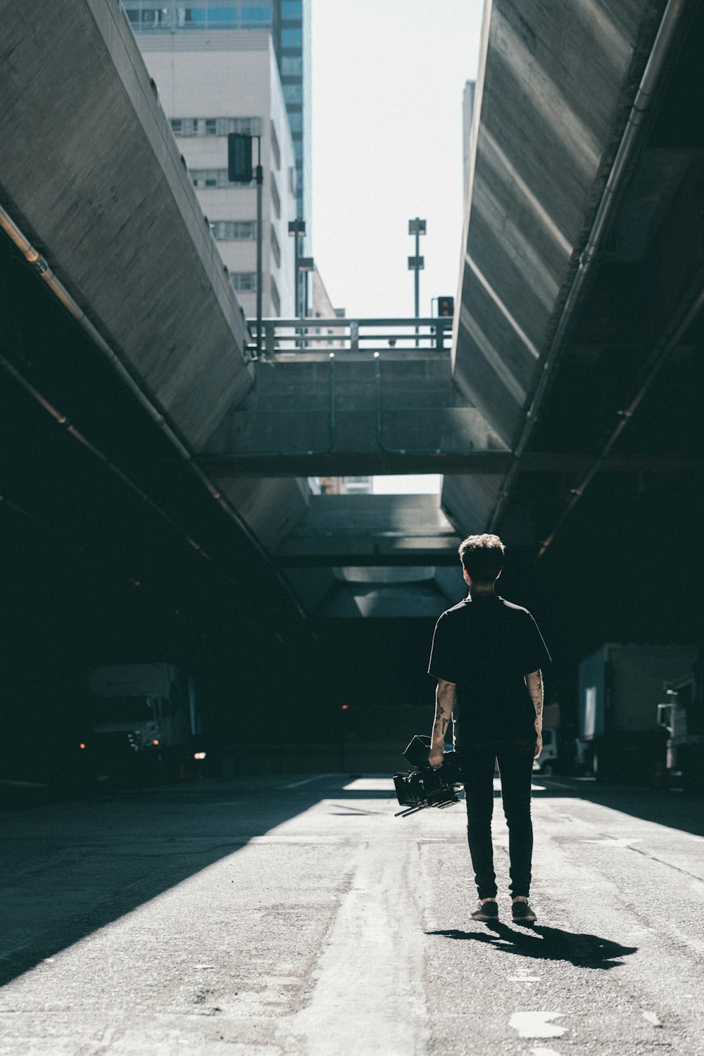 man walking under the bridge