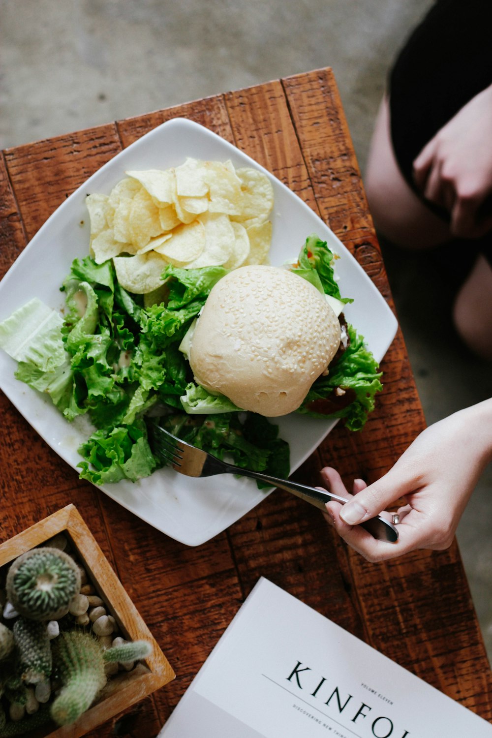 bun, lettuce, and chips served on white ceramic plate