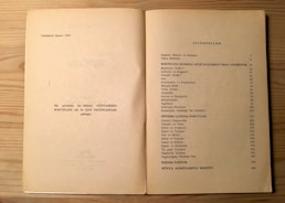 The image shows an open book on a light wood surface. The left page contains some text in Turkish, mentioning the fourth edition from 1982, and a note about the publication. The right page features a table of contents titled 'İÇİNDEKİLER', listing topics related to Bertrand Russell, philosophical and modern issues, with corresponding page numbers.