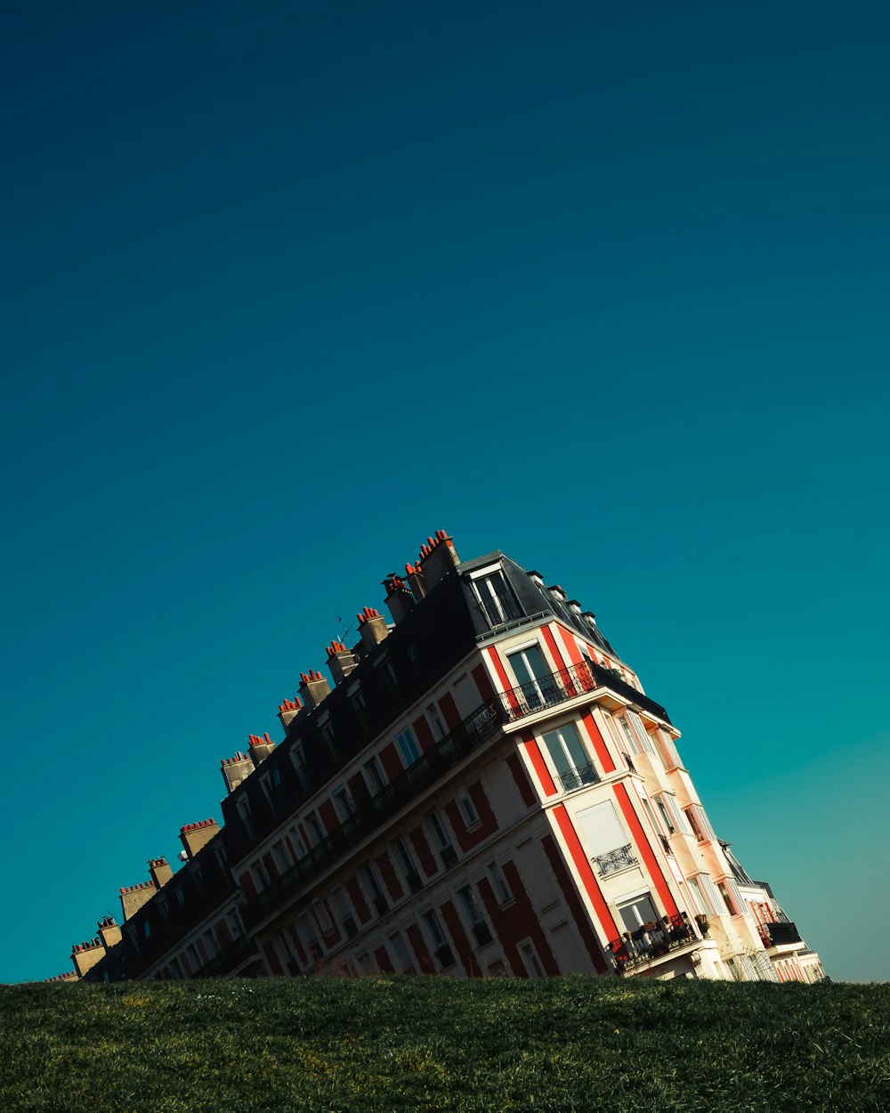 Edificio de hormigón blanco y rojo bajo el cielo verde azulado