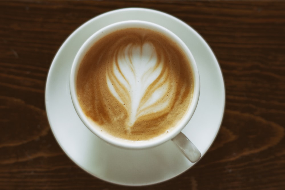 A flower shape on top of a cup of coffee.