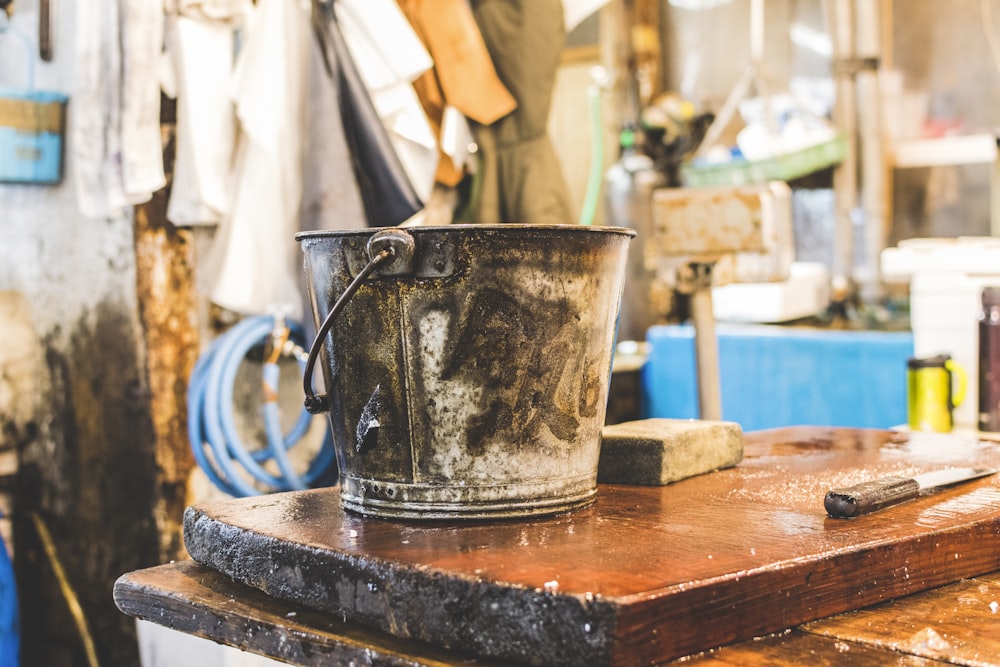 gray bucket on wooden table