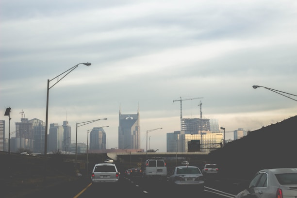 A city skyline with a truck driving on the road.