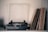 A vintage turntable is placed on a shelf alongside a collection of vinyl records stacked vertically. The turntable has a clear dust cover partially open, and the records have varying cover designs, suggesting a diverse collection. Soft lighting creates a nostalgic atmosphere.
