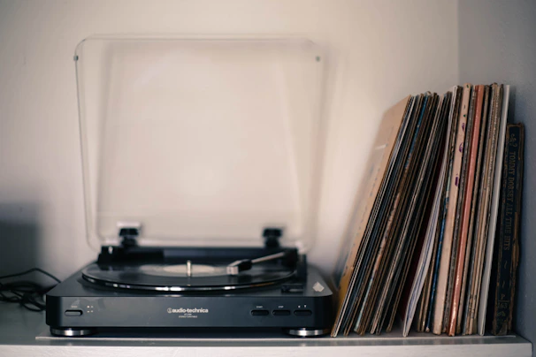 Close-up of vintage vinyl records stacked with a retro turntable in the background.