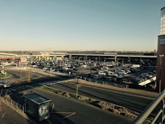 A spacious parking lot filled with parked cars under a clear blue sky.