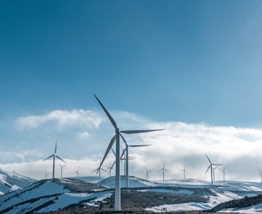 wind turbines on snowy mountain under clear blue sky during daytime