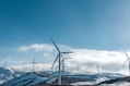 wind turbines on snowy mountain under clear blue sky during daytime