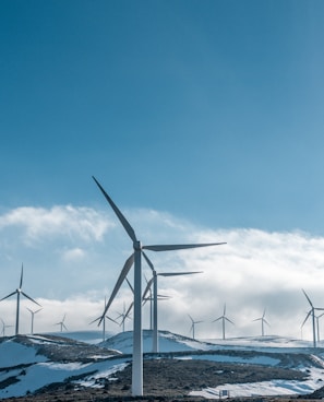 wind turbines on snowy mountain under clear blue sky during daytime