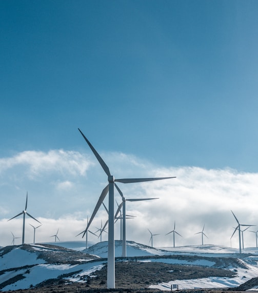 wind turbines on snowy mountain under clear blue sky during daytime