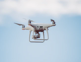 white DJI drone in mid air