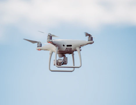 white DJI drone in mid air