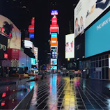 Times Square at night glowing with neon lights and crowds of excited visitors