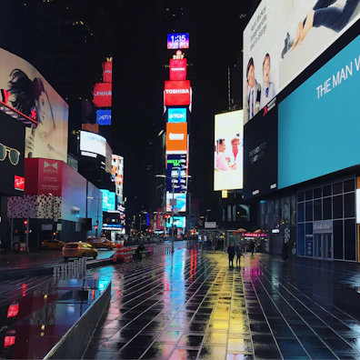 Times Square at night glowing with neon lights and crowds of excited visitors