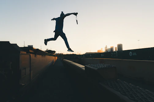 Jerry mid-air during a wire stunt against a city skyline backdrop.