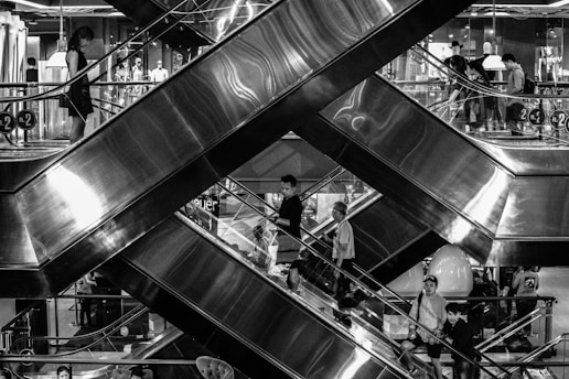 A newly installed escalator in a busy shopping mall with people using it.