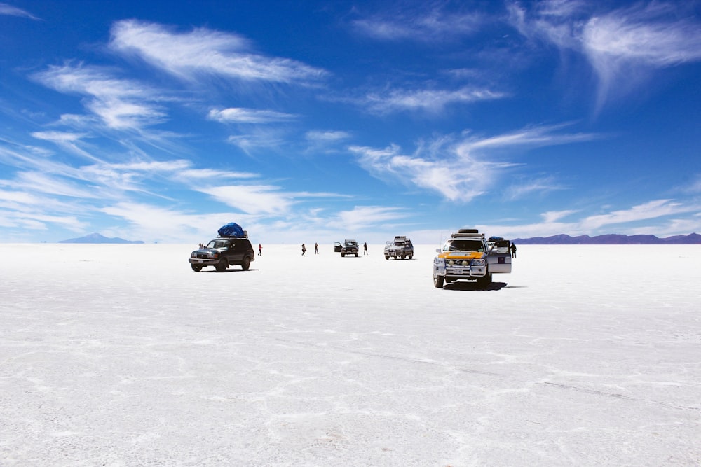 낮 동안 흐린 푸른 하늘 아래 사막을 달리는 스포츠 유틸리티 차량