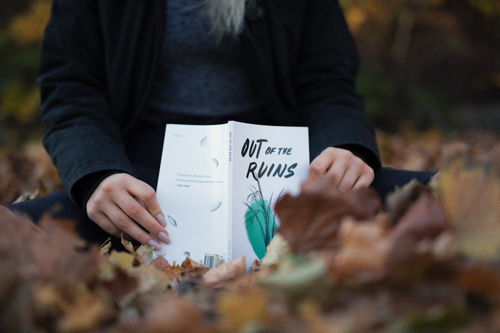 Person, die das Buch "Out Of The Ruins" in der Hand hält
