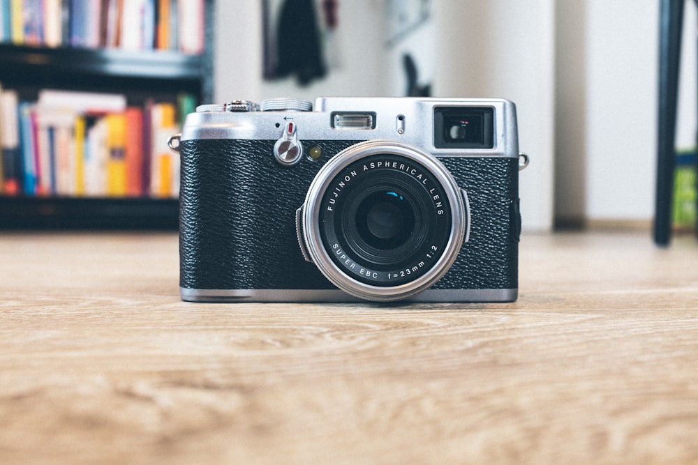 black and gray camera on brwon wooden surface