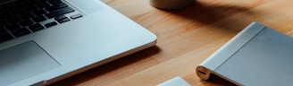 MacBook Pro beside brown ceramic mug