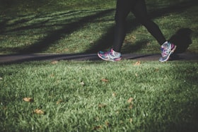 Pernas femininas com calça de ginástica e tênis durante uma corrida 