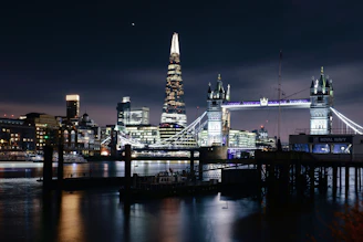 A nighttime cityscape of Newcastle upon Tyne with illuminated bridges and historic architecture.