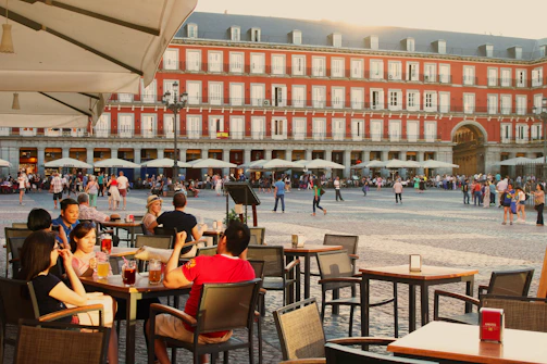 A lively Spanish restaurant terrace with people enjoying tapas and drinks.