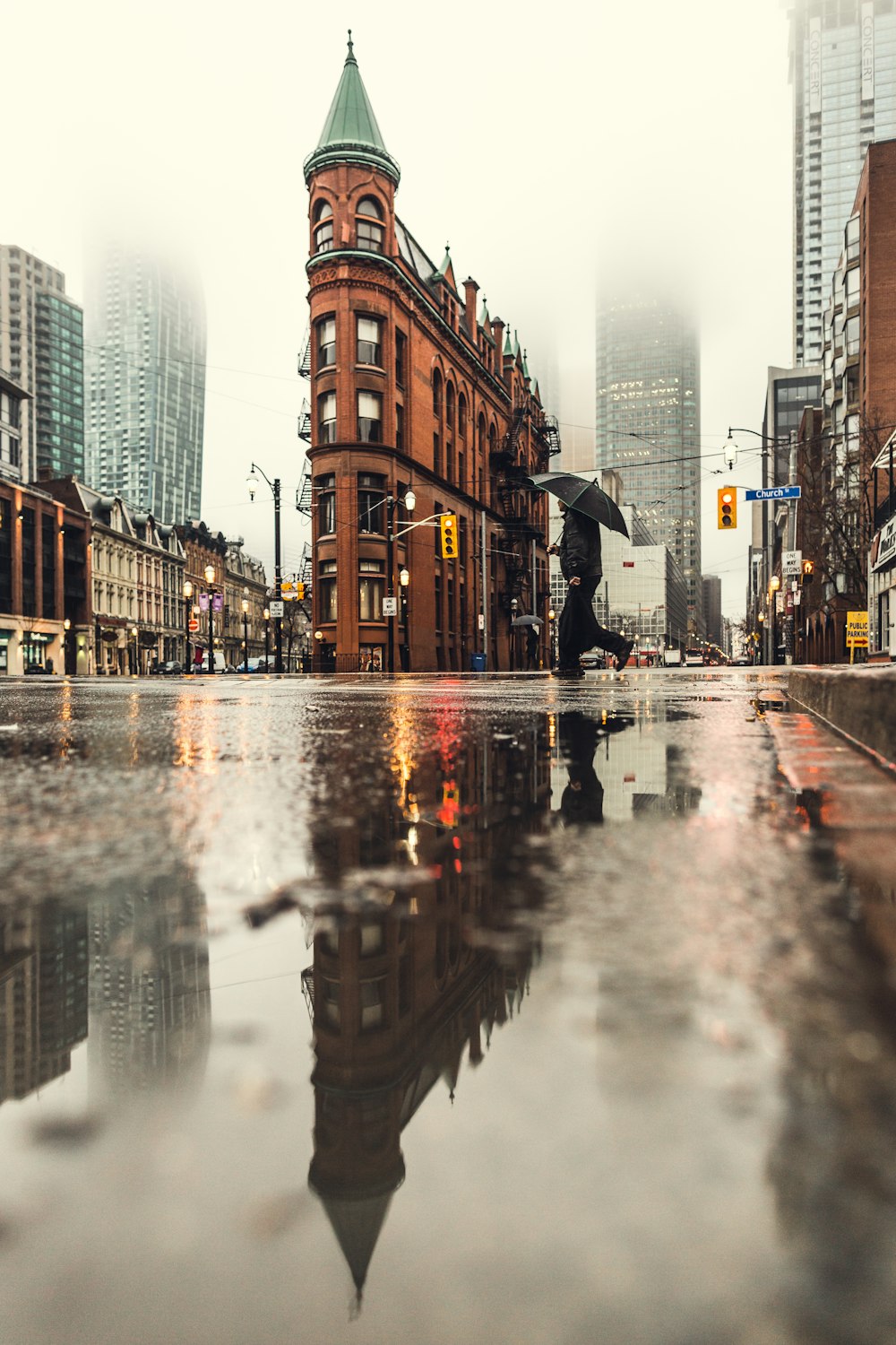 日中に傘をさして道路を横断する男性