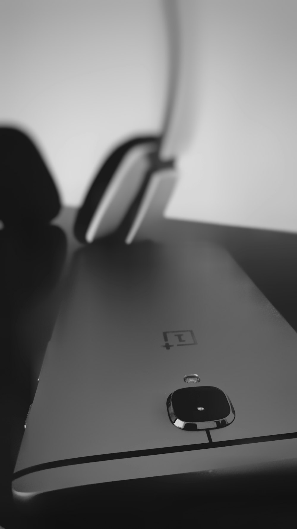 Um smartphone preto perto de fones de ouvido.