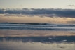 A scenic beach view with surfers enjoying the waves.