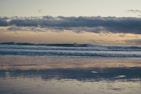 A scenic beach view with surfers enjoying the waves.