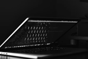 Soft-focus image of a laptop keyboard with code reflections.