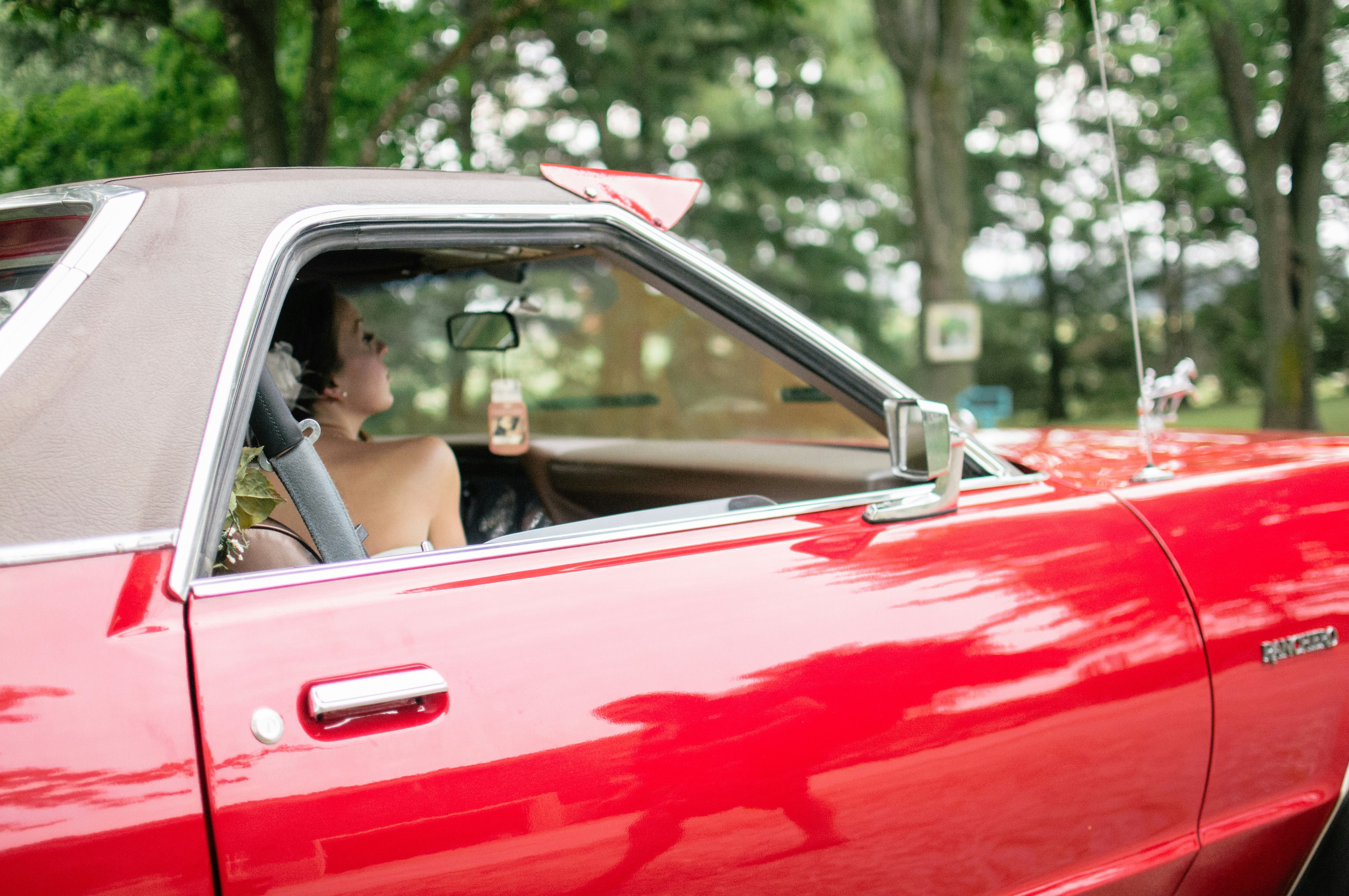 woman riding on red coupe
