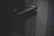Close-up of a matte black door handle installed on a wooden door with soft natural light.